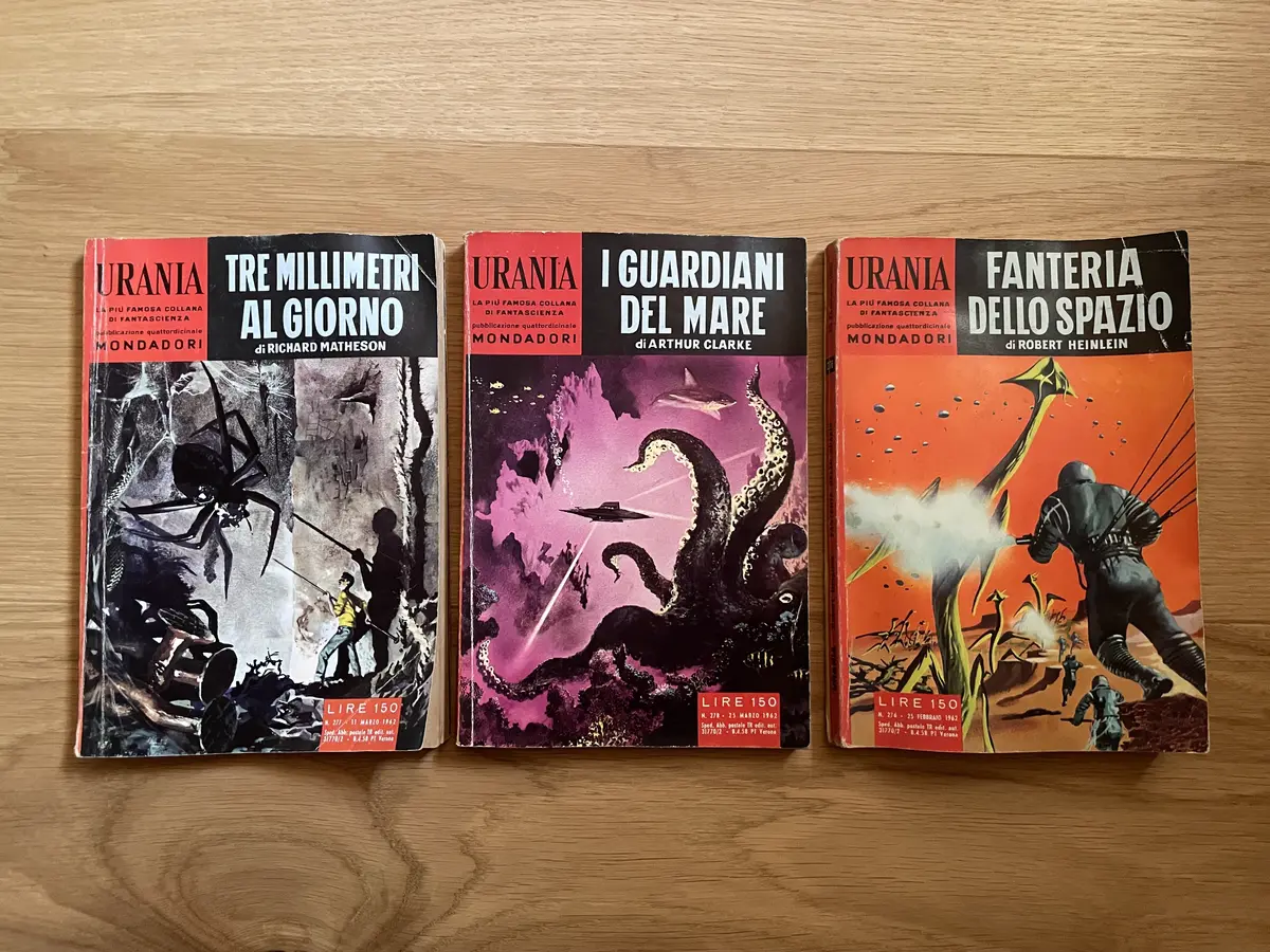 Three books aligned on the parquet. From left to right: ‘The Shrinking Man’ by Matheson, ‘The Deep Range’ by Clarke anb ‘Starship Troopers’ by Heinlein